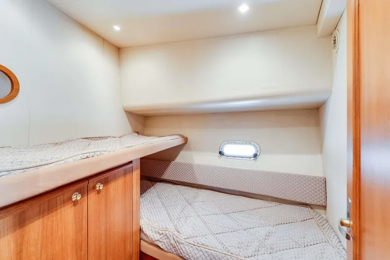 Slide: The Image of 1998 Bayliner 5788 Pilot House Motoryacht cabin with cozy bunk beds and wooden cabinetry. - 110