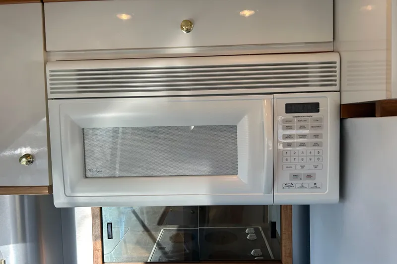 Slide: The Image of 1998 Bayliner 5788 Pilot House Motoryacht interior with blue leather seating and wooden table. - 27