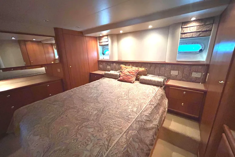 Slide: The Image of 1998 Bayliner 5788 Pilot House Motoryacht bathroom with wooden cabinetry and mirrored walls. - 48