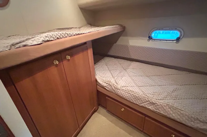 Slide: The Image of 1998 Bayliner 5788 Pilot House Motoryacht 3rd cabin with bunk beds and wooden cabinetry. - 62