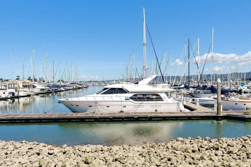Slide: The Image of 1998 Bayliner 5788 Pilot House Motoryacht docked in a marina under a clear blue sky. - 80