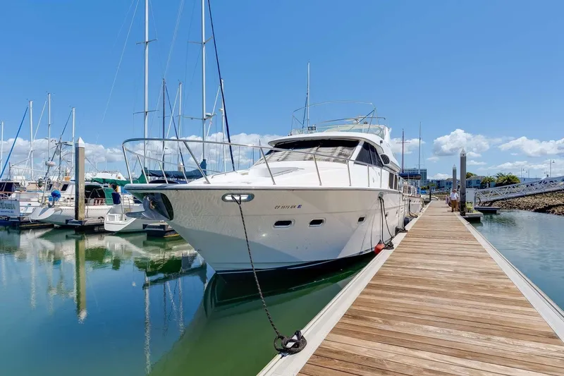 Slide: The Image of 1998 Bayliner 5788 Pilot House Motoryacht docked at marina under clear blue sky. - 81