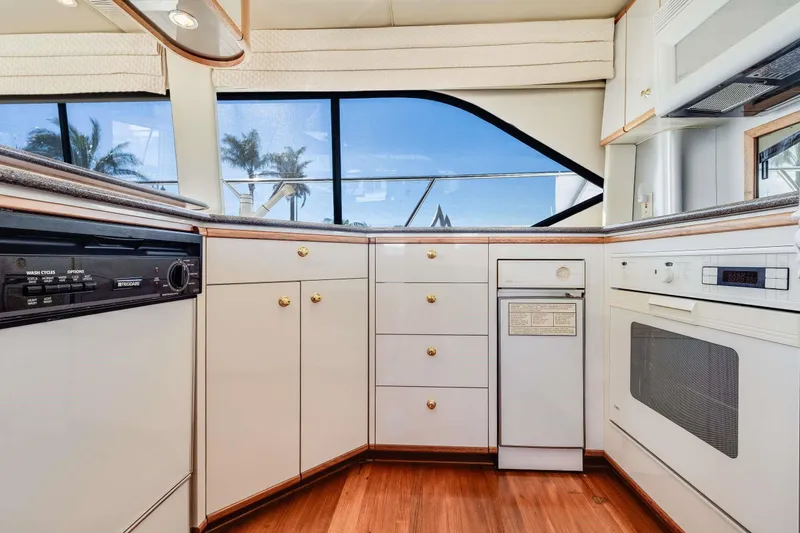 Slide: The Image of Interior kitchen of 1998 Bayliner 5788 Pilot House Motoryacht with modern appliances and wood flooring. - 91