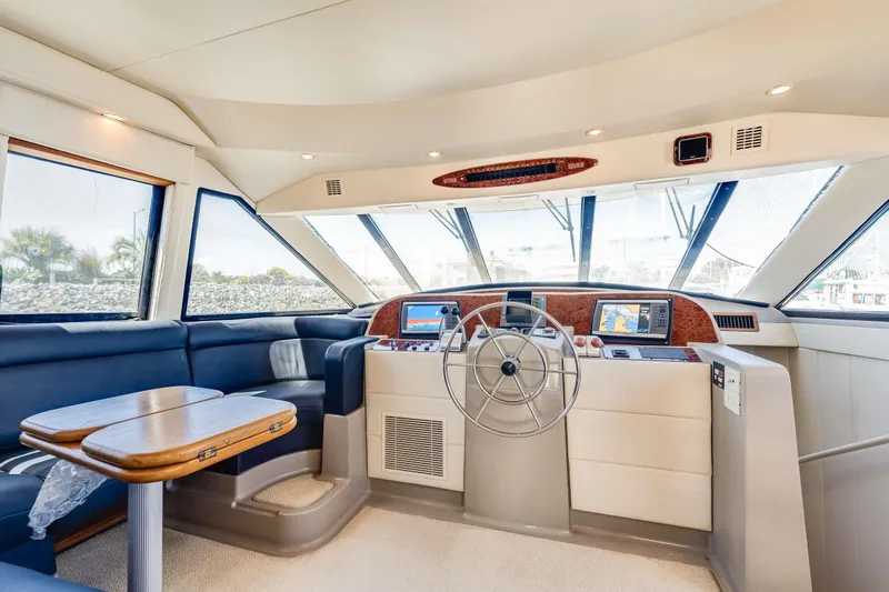 Slide: The Image of 1998 Bayliner 5788 Pilot House Motoryacht interior with helm, navigation screens, and seating area. - 96