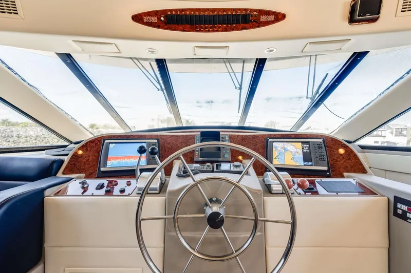 Slide: The Image of 1998 Bayliner 5788 Pilot House Motoryacht helm with navigation screens and steering wheel. - 97