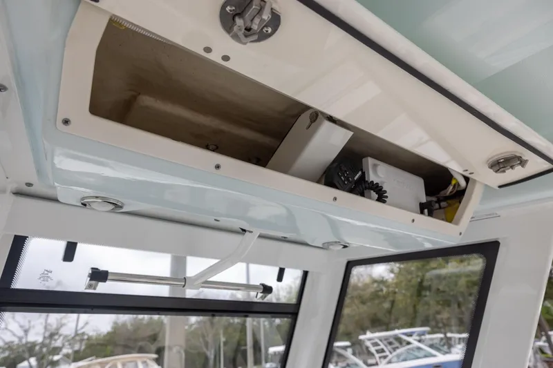 Slide: The Image of 2021 Robalo R272 Center Console storage compartment with electronic equipment. - 13
