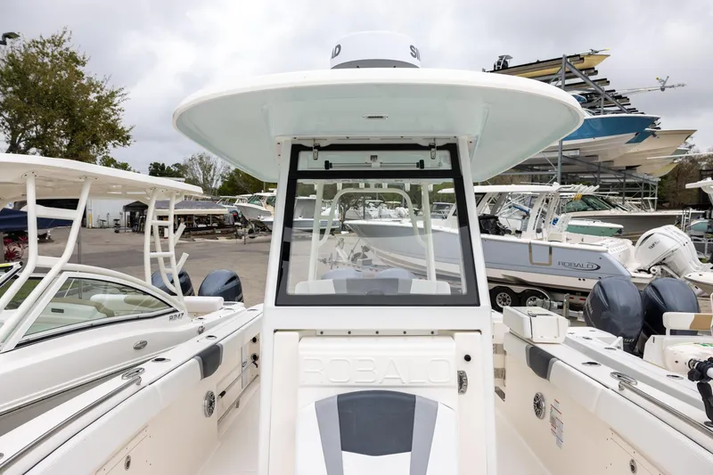 Slide: The Image of 2021 Robalo R272 Center Console boat at a marina, surrounded by other vessels. - 17