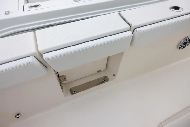 Slide: The Image of 2021 Robalo R272 Center Console boat seating area with white cushions and stainless steel fixtures. - 9