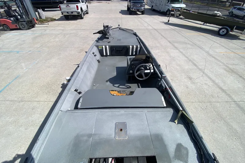 Slide: The Image of 1996 War Eagle 761 Renegade boat interior with steering console, parked in a lot. - 11