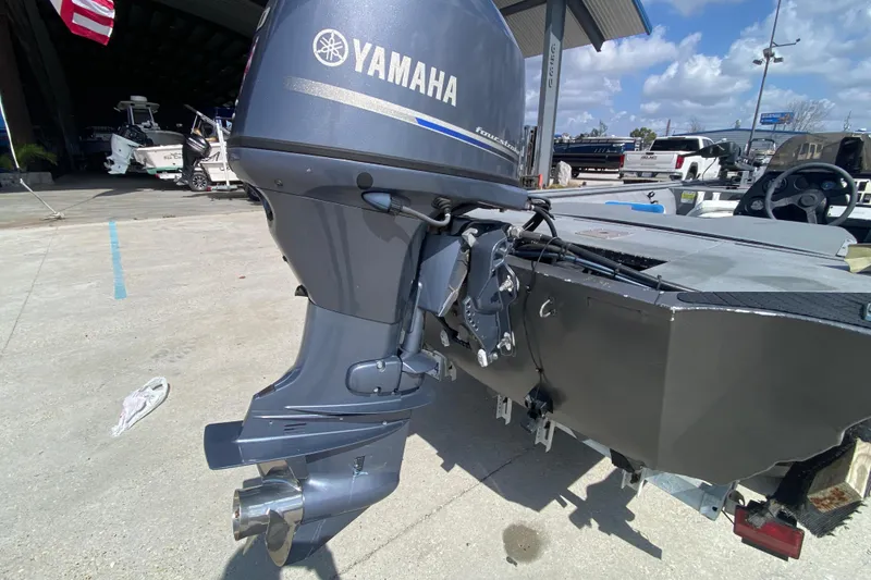 Slide: The Image of Outboard motor on 1996 War Eagle 761 Renegade boat, parked outdoors. - 4