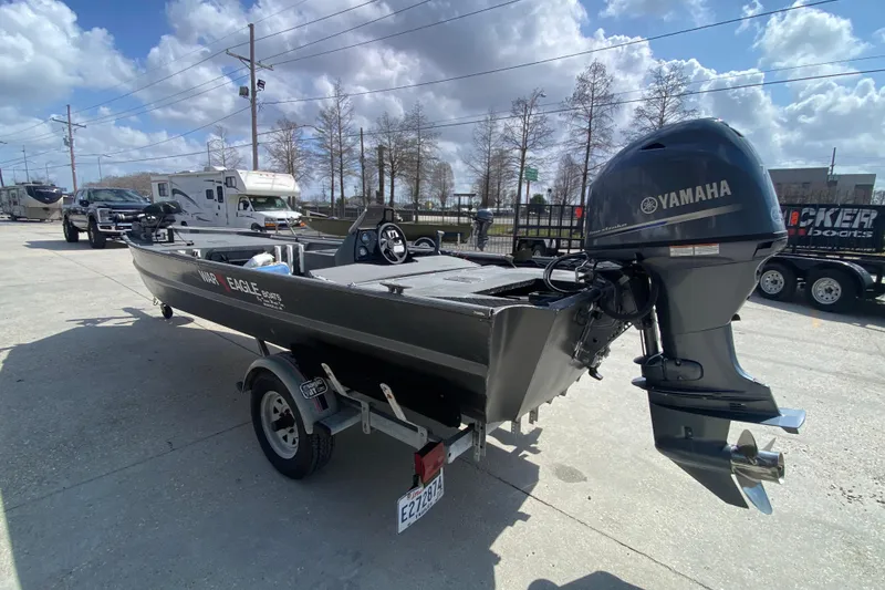 Slide: The Image of 1996 War Eagle 761 Renegade boat with Yamaha motor on trailer, parked outdoors. - 7