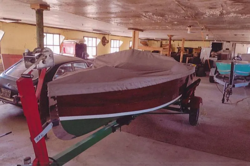 Slide: The Image of 1931 Dodge 16' Sea Nymph boat covered in a garage with vintage car nearby. - 18