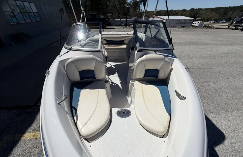 Slide: The Image of 2013 TAHOE Q5i boat with white and blue seats outdoors. - 9