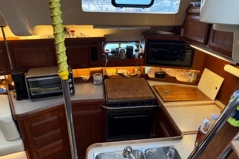 Slide: The Image of Cozy 1997 Hunter Passage 42 yacht kitchen with wooden cabinetry and modern appliances. - 13