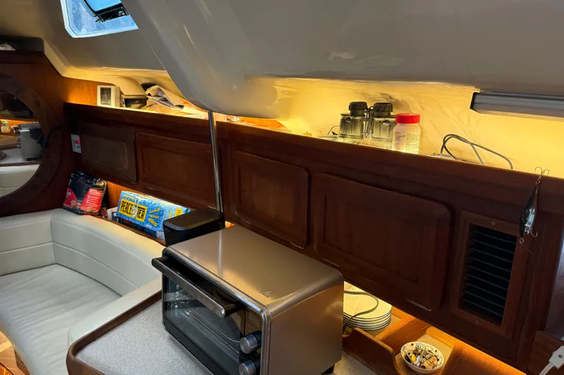 Slide: The Image of Interior of 1997 Hunter Passage 420 sailboat with cozy seating and wooden accents. - 14