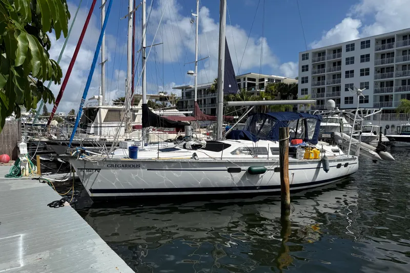Slide: The Image of 1997 Hunter Passage 420 sailboat docked in marina, surrounded by other boats and buildings. - 2