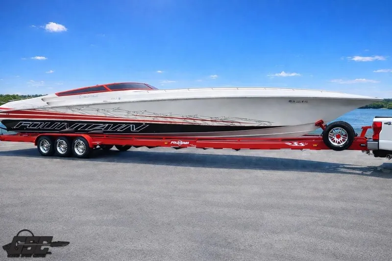Slide: The Image of 2009 Fountain 47 Lightning speedboat on red trailer by a lake under blue sky. - 118