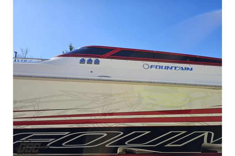 Slide: The Image of 2009 Fountain 47 Lightning boat with sleek design and vibrant graphics under clear blue sky. - 22