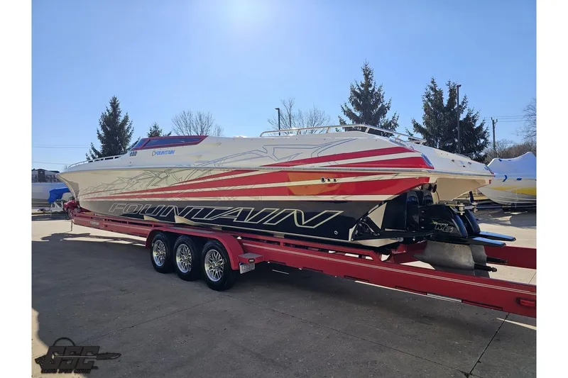 Slide: The Image of 2009 Fountain 47 Lightning speedboat on red trailer, vibrant graphics, parked outdoors. - 26