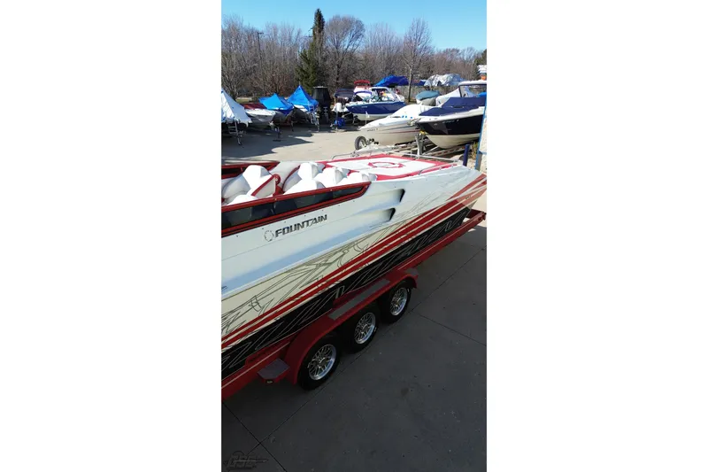 Slide: The Image of 2009 Fountain 47 Lightning speedboat on trailer, parked outdoors with other boats. - 41