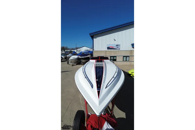 Slide: The Image of 2009 Fountain 47 Lightning boat with sleek design, parked outdoors under clear blue sky. - 42