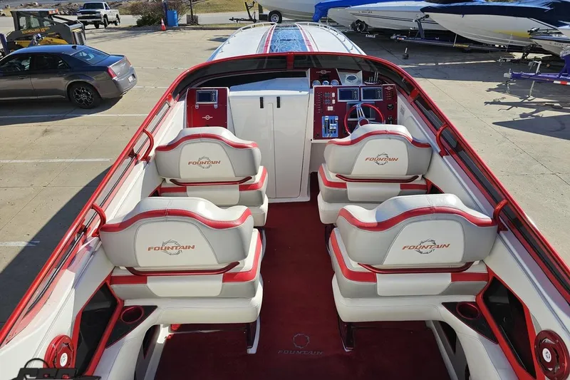 Slide: The Image of 2009 Fountain 47 Lightning boat interior with red and white seating, docked outdoors. - 58