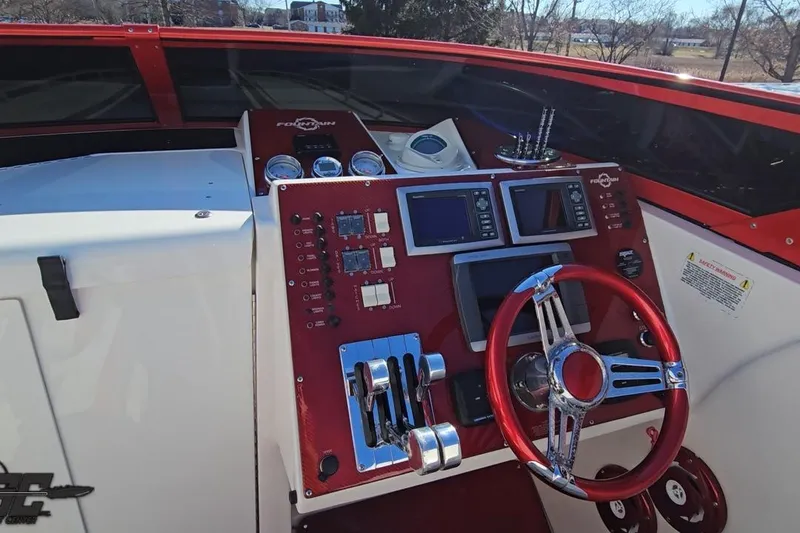 Slide: The Image of 2009 Fountain 47 Lightning boat dashboard with red accents and advanced controls. - 77