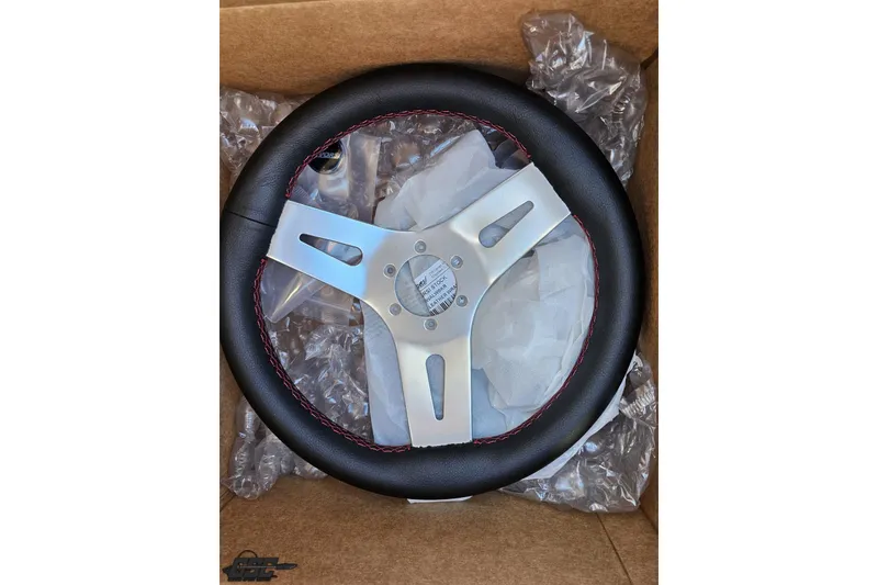 Slide: The Image of Steering wheel for 2009 Fountain 47 Lightning, featuring black leather and red stitching. - 79