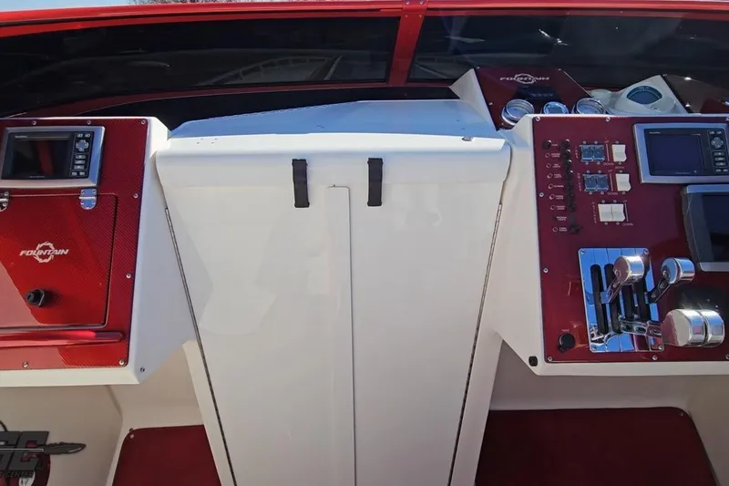 Slide: The Image of 2009 Fountain 47 Lightning boat dashboard with red accents and control panels. - 85
