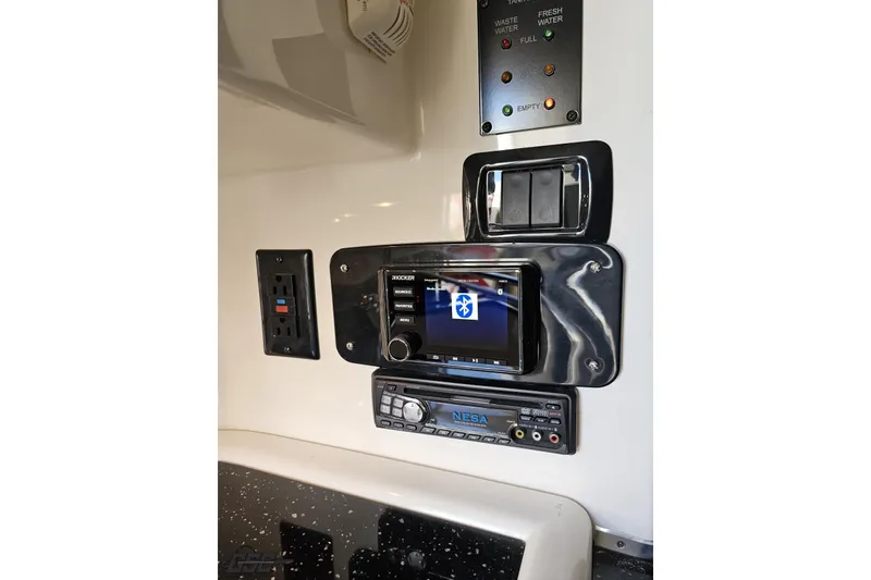 Slide: The Image of Control panel of a 2009 Fountain 47 Lightning boat with audio and water level indicators. - 97