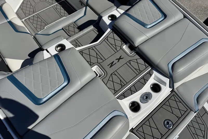 Slide: The Image of 2021 Tigé 21ZX boat interior with gray and blue cushioned seating and cup holders. - 13