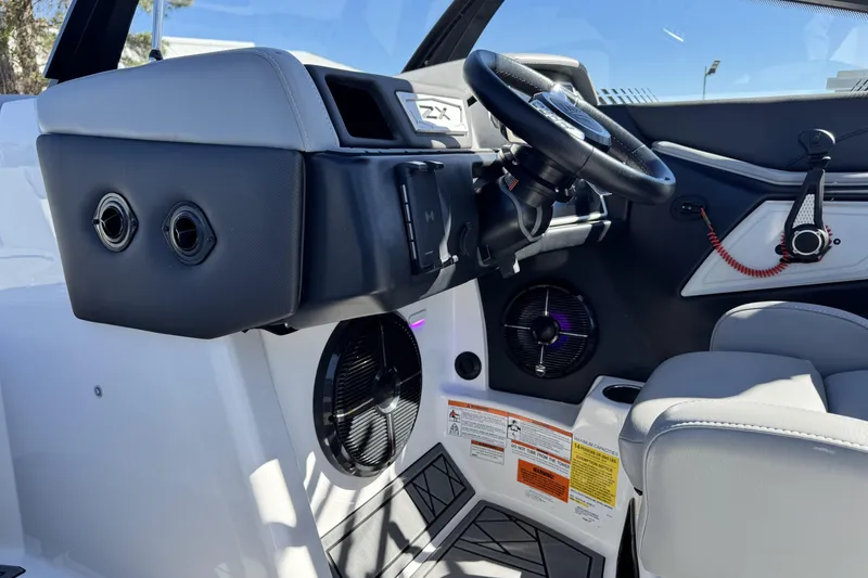 Slide: The Image of 2021 Tigé 21ZX boat interior with steering wheel and speaker system. - 16