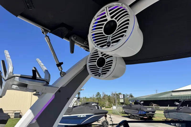 Slide: The Image of 2021 Tigé 21ZX boat with mounted speakers and wakeboard rack under clear blue sky. - 8