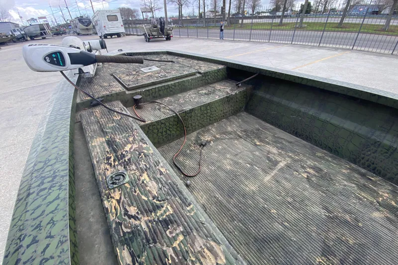 Slide: The Image of Custom Charles Leonard Skiff 2016 with camouflage design and trolling motor in parking lot. - 12