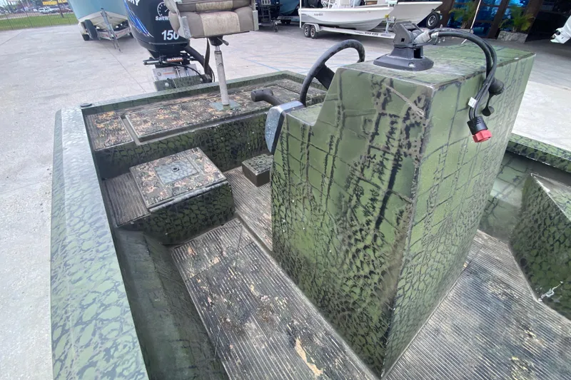 Slide: The Image of Green camo-patterned 2016 Charles Leonard Skiff boat interior with motor and seating. - 15