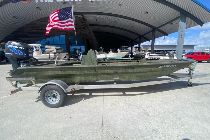 Slide: The Image of Custom 2016 Charles Leonard Skiff on trailer, with American flag and Mercury outboard motor. - 2