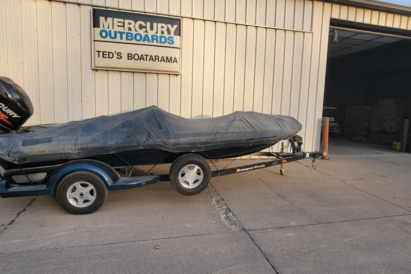 Slide: The Image of 2001 Ranger 518DVX Comanche boat covered, parked outside Ted's Boatarama. - 17