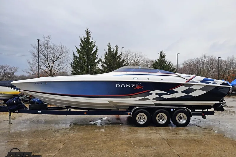 Slide: The Image of 2000 Donzi 33 ZX speedboat on trailer, featuring sleek design and checkered graphics. - 11