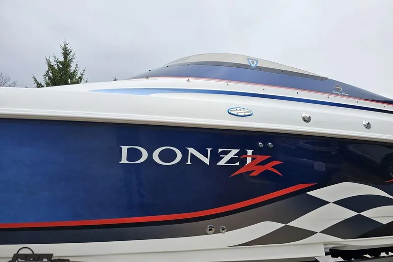 Slide: The Image of 2000 Donzi 33 ZX boat with blue and white design, side view. - 13