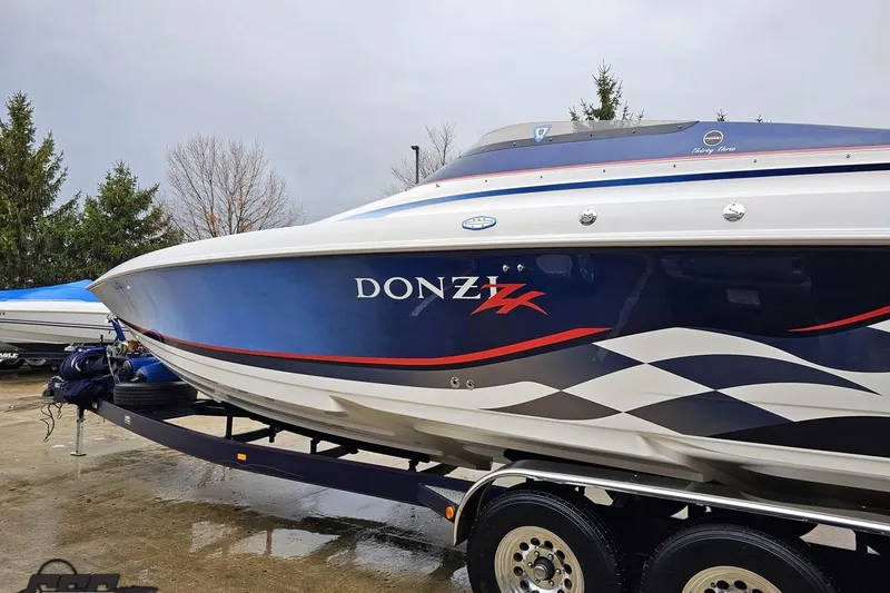Slide: The Image of 2000 Donzi 33 ZX speedboat with sleek blue and white design on trailer. - 15