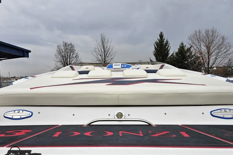 Slide: The Image of 2000 Donzi 33 ZX boat with sleek design, white upholstery, and red accents under cloudy sky. - 23