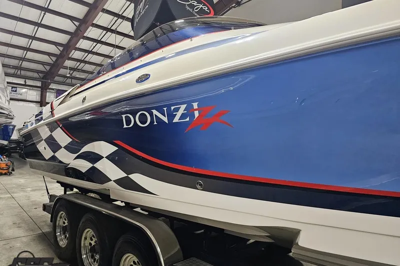 Slide: The Image of 2000 Donzi 33 ZX speedboat with blue and white design in a warehouse. - 25