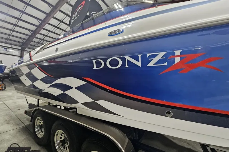 Slide: The Image of 2000 Donzi 33 ZX speedboat with blue and white design in a storage facility. - 26