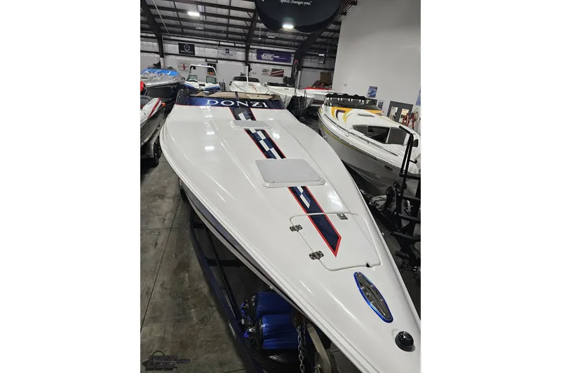 Slide: The Image of 2000 Donzi 33 ZX speedboat in showroom, showcasing sleek design and vibrant graphics. - 28