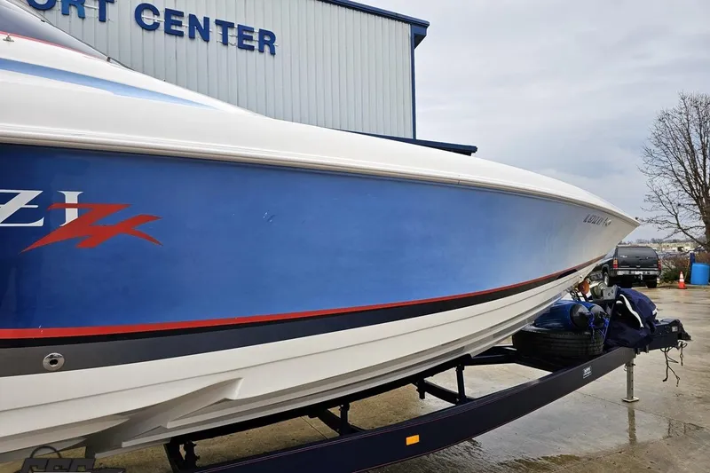 Slide: The Image of 2000 Donzi 33 ZX boat with blue and white hull on trailer at a sport center. - 3