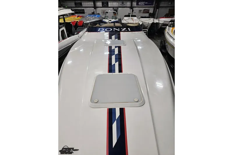 Slide: The Image of 2000 Donzi 33 ZX boat with sleek design and racing stripes in showroom. - 30