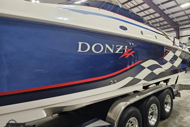 Slide: The Image of 2000 Donzi 33 ZX boat with blue and white design in a warehouse setting. - 31