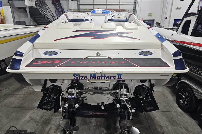 Slide: The Image of 2000 Donzi 33 ZX boat in showroom, rear view with "Size Matters II" text. - 32