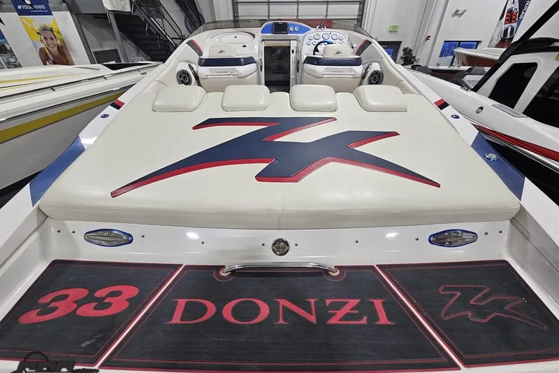 Slide: The Image of 2000 Donzi 33 ZX boat interior with logo, white seating, and dashboard view. - 33