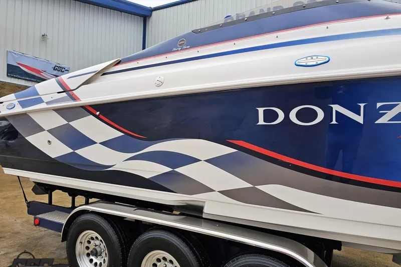 Slide: The Image of 2000 Donzi 33 ZX boat with blue and white checkered design on trailer. - 4